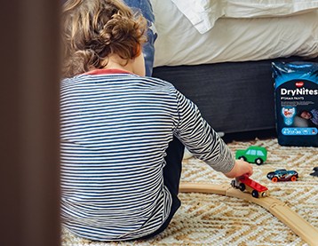 Boy playing with toys on his bedroom floor