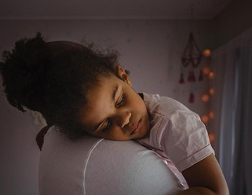 Sleeping girl on a parent's shoulder