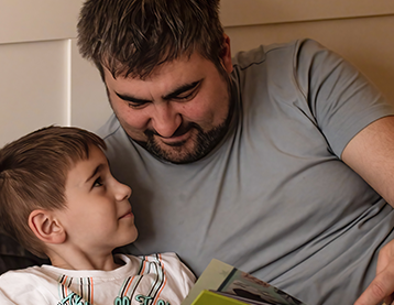 Dad reading a book with his son